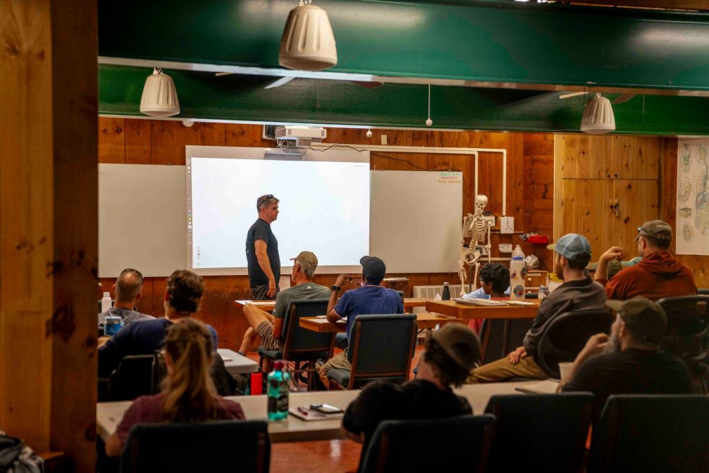 Instructor teaching students in a classroom with skeleton